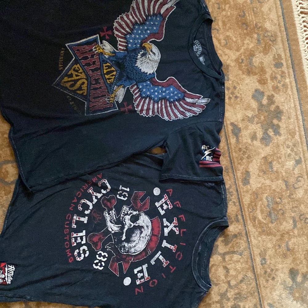 Two black big boys size medium and size large Affliction brand T-shirts.
